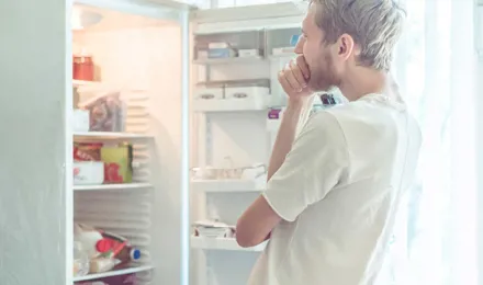 Muškarac traži hranu u hladnjaku