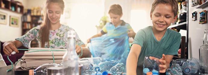 3 παιδιά προσπαθούν να καταλάβουν τι μπορούν να ανακυκλώσουν, βάζοντας διάφορα είδη πλαστικών σε κάδους στην κουζίνα