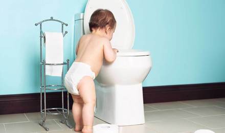 Ein Kleinkind schaut in eine Toilette