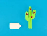 Feldíszített kartondoboz kartonhallal és egy kaktusz alakú játék a kertben gyerekeknek
04