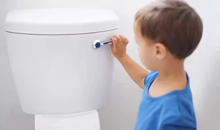 Malý kluk splachuje toaletu
