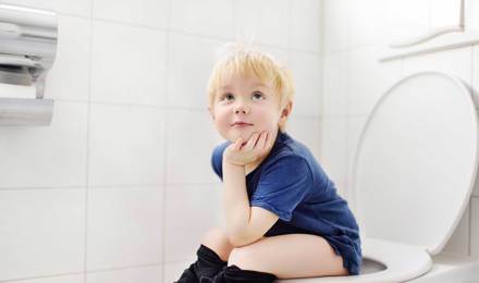 Ein Kleinkind sitzt auf einer Toilette