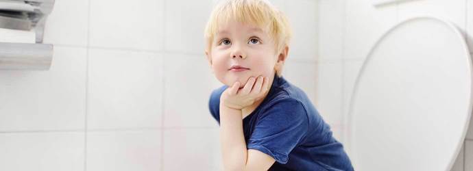 Ein Kleinkind sitzt auf einer Toilette