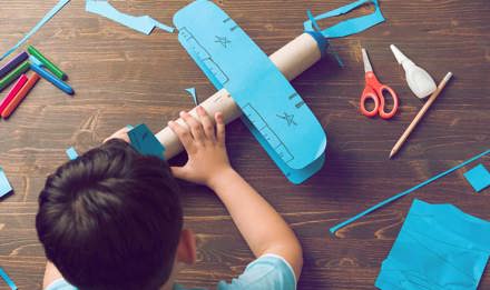 Ein Kind bastelt ein Flugzeug aus Pappe