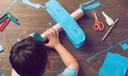Ein Kind bastelt ein Flugzeug aus Pappe
